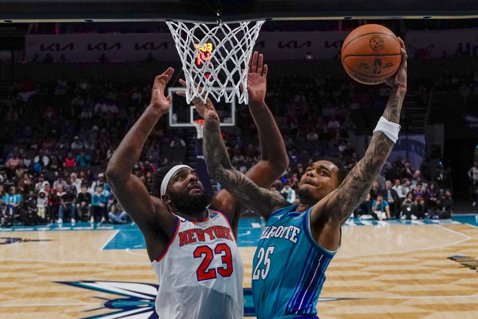 Charlotte Hornets forward P.J. Washington shoot over New York Knicks center Mitchell Robinson during the first half of an NBA basketball game on Saturday, Nov. 18, 2023, in Charlotte, N.C. (AP Photo/Chris Carlson)