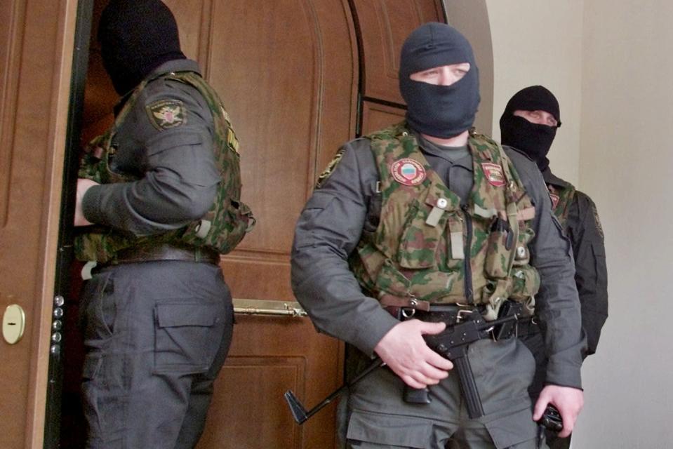 FILE - Masked and armed police officers stand outside central office of Media-Most holding company in Moscow on May 11, 2000. Tax police raid the offices of NTV, a popular independent broadcaster noted for critical coverage of the Kremlin. It is the first salvo in moves against prominent independent media that have characterized the Putin era. (AP Photo/Misha Japaridze, File)