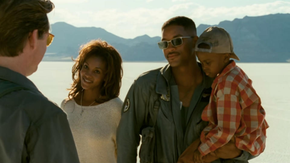 Bill Pullman stands in conversation with Vivica A Fox, Will Smith, and Ross Bagley in Independence Day.