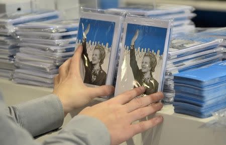 A stall holder arranges items for sale commemorating the late British Conservative Party Prime Minister Margaret Thatcher on the first day of the Conservative Party annual conference in Manchester, northern England September 29, 2013. REUTERS/Toby Melville