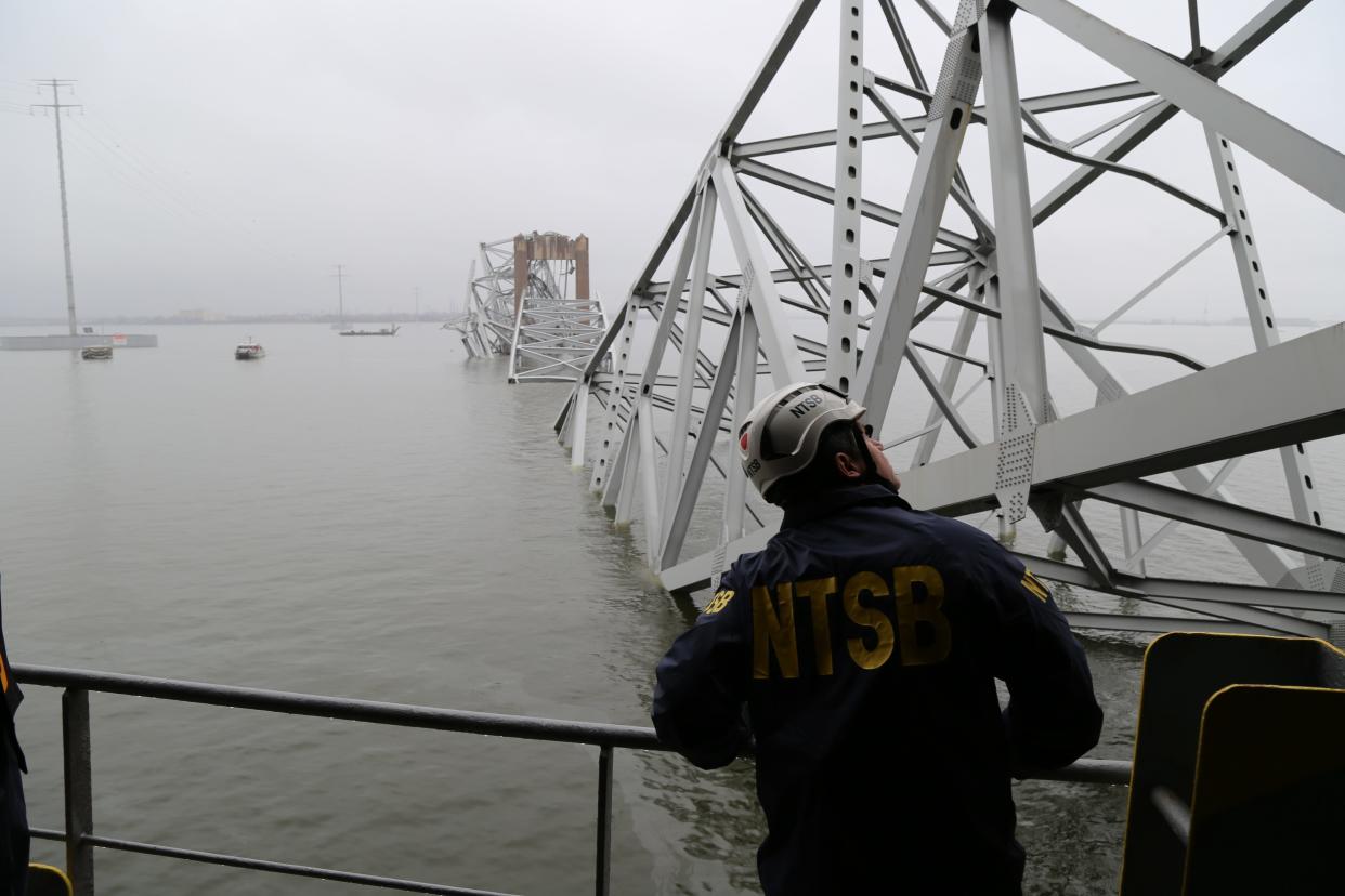NTSB investigators are seen March 27, 2024, on the cargo vessel Dali, which struck and collapsed the Francis Scott Key Bridge on March 26, 2024.