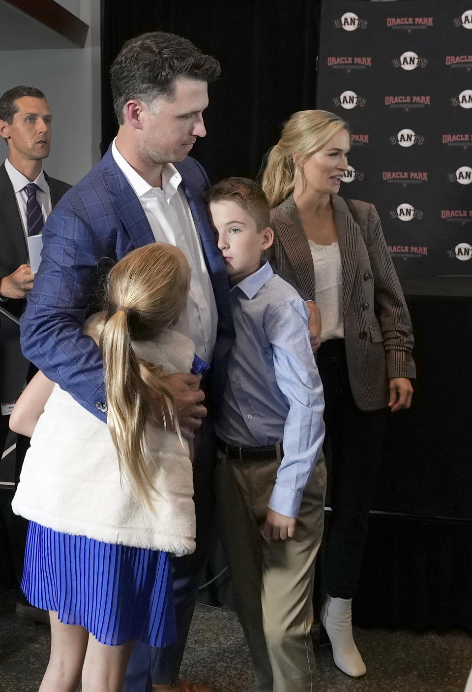 San Francisco Giants catcher Buster Posey hugs his children Addison and Lee, next to his wife, Kristen, right, after a news conference announcing his retirement from baseball, Thursday, Nov. 4, 2021, in San Francisco. (AP Photo/Tony Avelar)