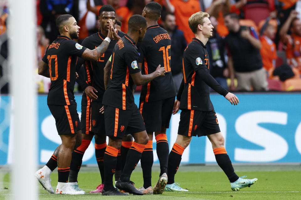 Memphis Depay of the Netherlands, left, celebrates after scoring his side's opening goal during the Euro 2020 soccer championship group F match between North Macedonia and Netherlands, at the Johan Cruyff ArenA in Amsterdam, Netherlands, Monday, June 21 2021. (Koen van Weel/Pool via AP)