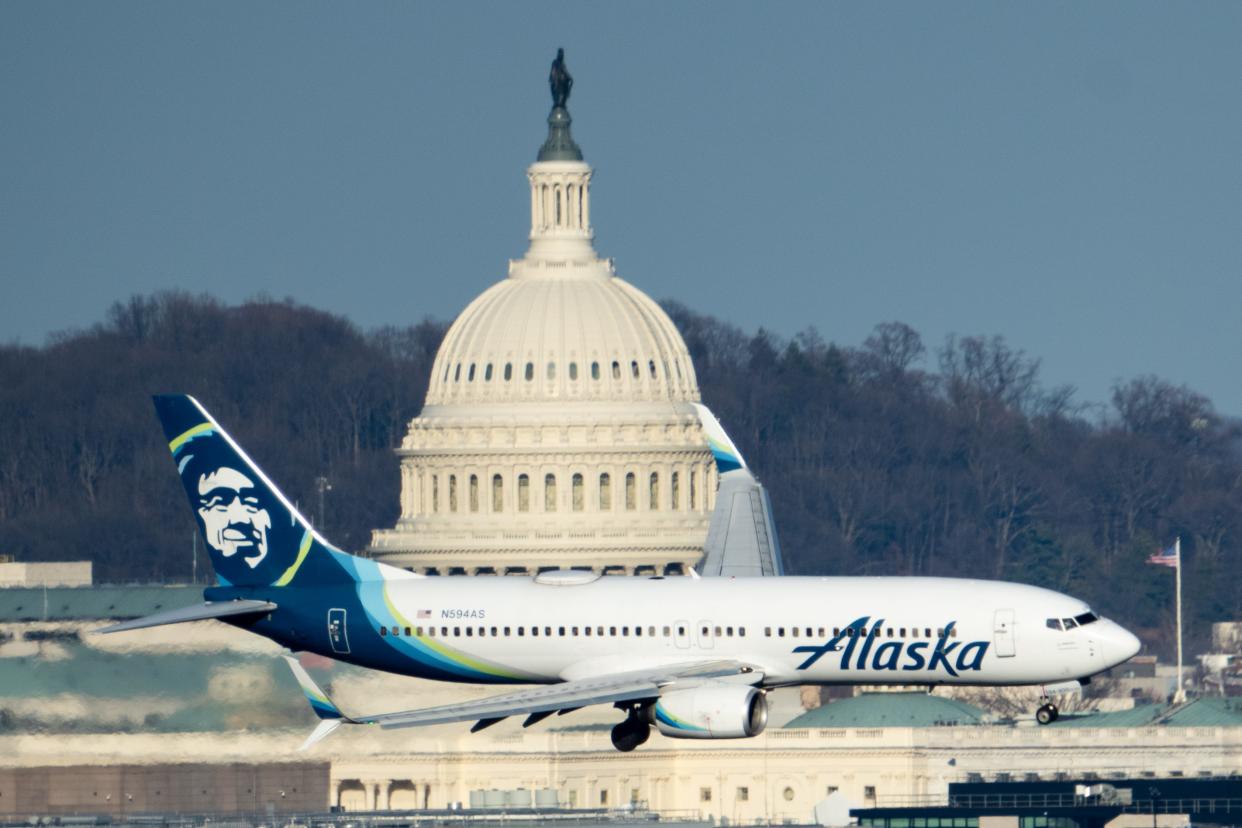 An Alaska Airlines Boeing 737-800 jet flies past the U.S. Capitol dome as it comes in for a landing at Washington Reagan National airport in Arlington, Va., on Thursday, February 15, 2024.