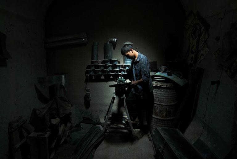 Unemployed Afghan Saber Rezayee helps out at his family's heater shop in Mazar-i-Sharif on September 20, 2013