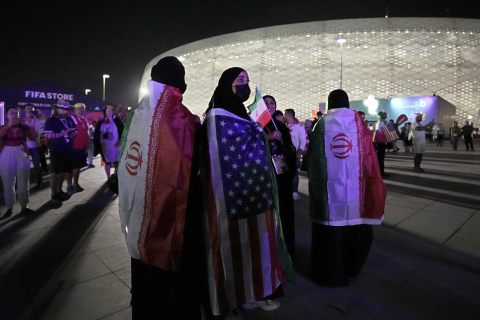 Aficionados con las banderias de Irán e Estados Unidos sobre sus hombros previo al partido por el Grupo B del Mundial, el martes 29 de noviembre de 2022, en Doha, Qatar. (AP Foto/Hassan Ammar)