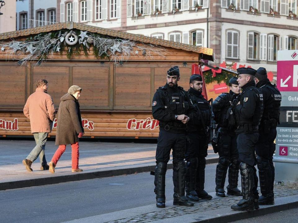 People walk past French Gendarmes who are standing guard in central Strasbourg two days after the deadly shooting (PATRICK HERTZOG/AFP/Getty Images)