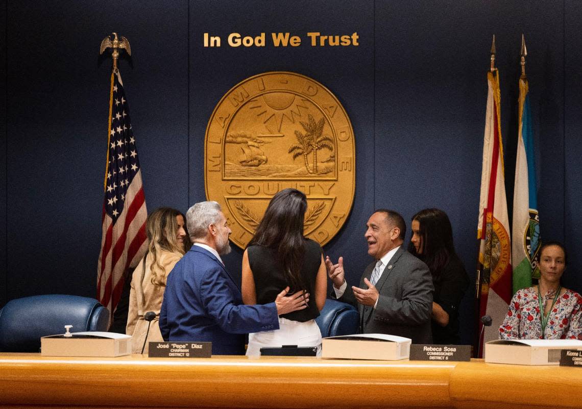 On Sept. 8, Commissioner Joe Martinez, right, talks to Commissioner Jose “Pepe” Diaz, left, and others before a Miami-Dade County budget hearing.