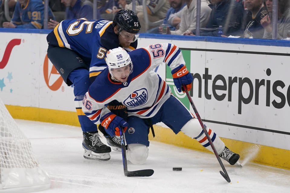 Edmonton Oilers' Kailer Yamamoto (56) and St. Louis Blues' Colton Parayko (55) chase after a loose puck along the boards during the third period of an NHL hockey game Wednesday, Oct. 26, 2022, in St. Louis. (AP Photo/Jeff Roberson)