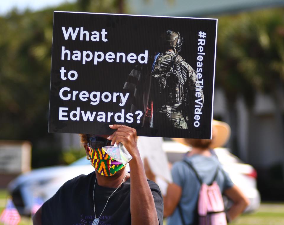 A protester holds aloft a sign featuring veteran Gregory Edwards during a 2020 protest outside the Moore Justice Center. Edwards died while in custody at the Brevard County Jail after a confrontation with deputies. FLORIDA TODAY sued to get the release of video from his time in jail.