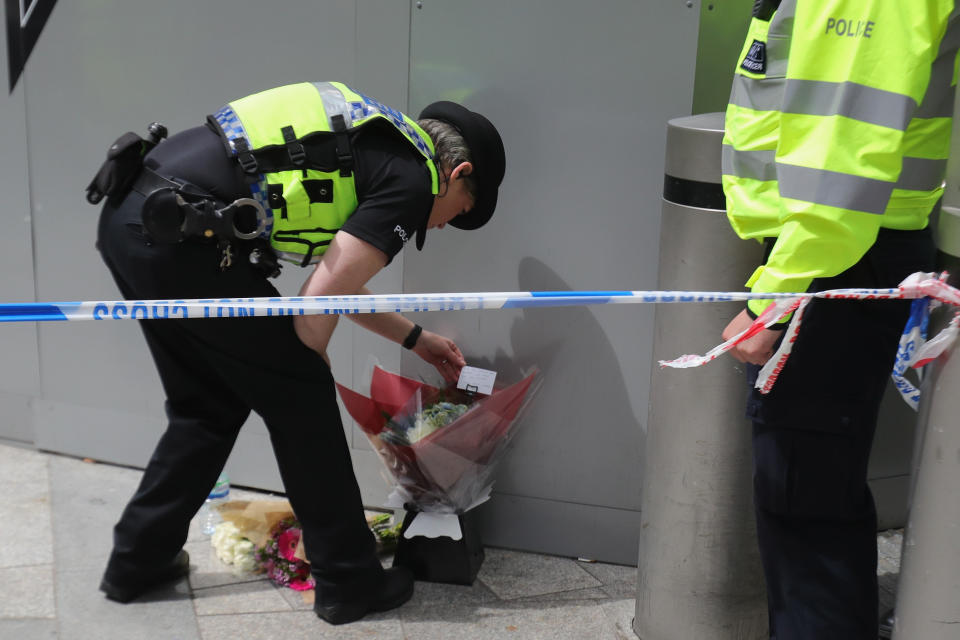 A police officer looks at a floral tribute left by a man near the scene of the terror attacks.&nbsp;