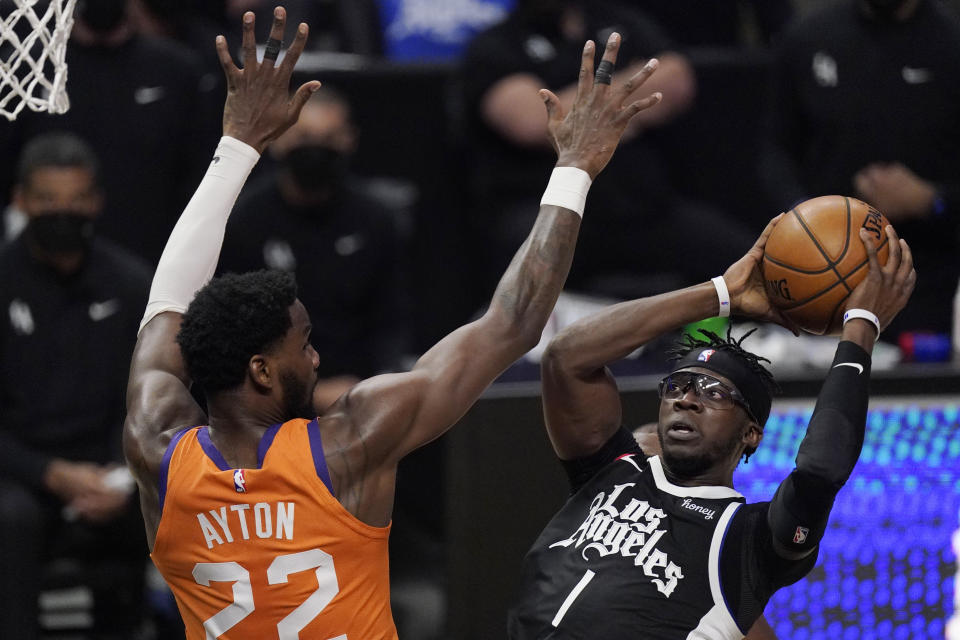 Los Angeles Clippers guard Reggie Jackson, right, shoots as Phoenix Suns center Deandre Ayton defends during the second half in Game 3 of the NBA basketball Western Conference Finals Thursday, June 24, 2021, in Los Angeles. (AP Photo/Mark J. Terrill)