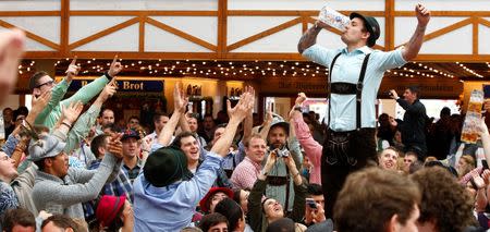 Visitors enjoy beer during their visit to the 181st Oktoberfest in Munich September 28, 2014. REUTERS/Michaela Rehle