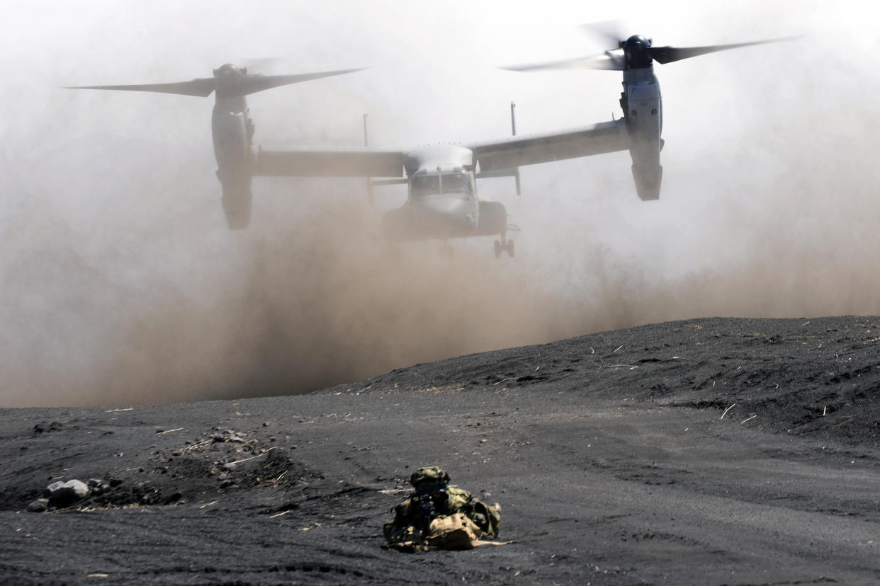 An MV-22 Osprey takes off as Japan's Ground Self-Defense Force personnel guard a landing zone during a joint military drill with U.S. Marines in Gotemba, southwest of Tokyo, March 15, 2022. / Credit: Eugene Hoshiko/AP