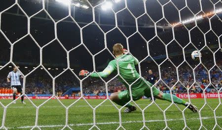 Argentina's Lionel Messi (L) shoots to score his penalty past Jasper Cillessen of the Netherlands during their shootout in their 2014 World Cup semi-finals at the Corinthians arena in Sao Paulo July 9, 2014. REUTERS/Dominic Ebenbichler