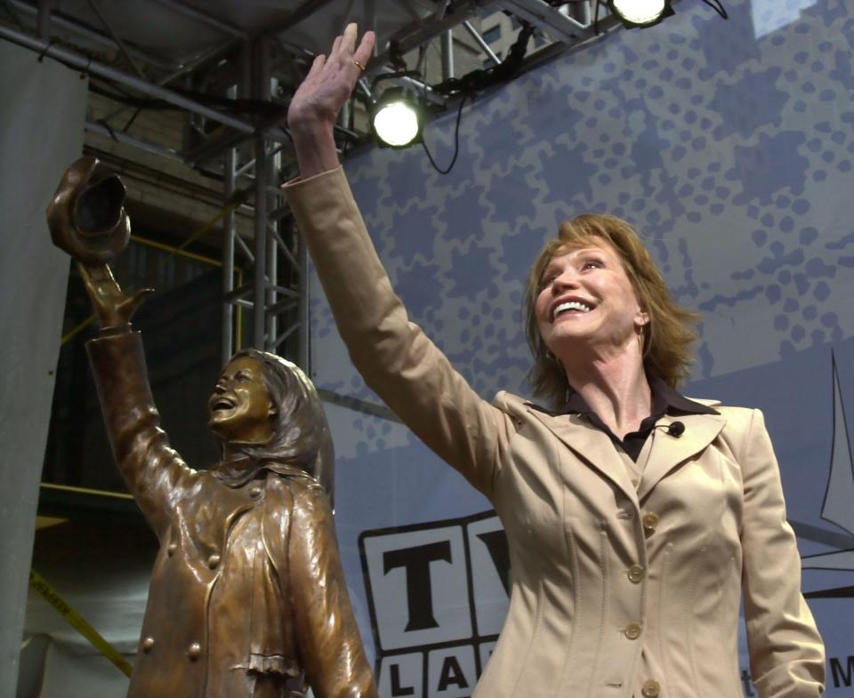 Mary Tyler Moore is mirrored by a bronze statue of herself after the unveiling of the statue capturing her flinging her tam as she did in the opening for her 1970s television hit, "The Mary Tyler Moore Show" in Minneapolis, May 8, 2002.