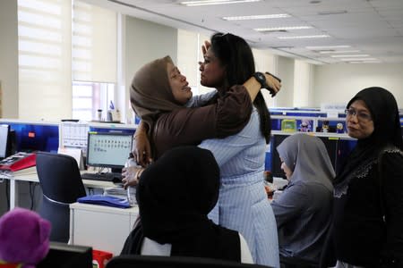 Employees of Utusan Malaysia react after the termination announcement at company's headquarters in Kuala Lumpur