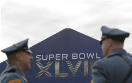 Members of the New Jersey State Police walk through the parking lot before the start of the NFL Super Bowl XLVIII football game in East Rutherford, New Jersey, February 2, 2014. REUTERS/Andrew Kelly