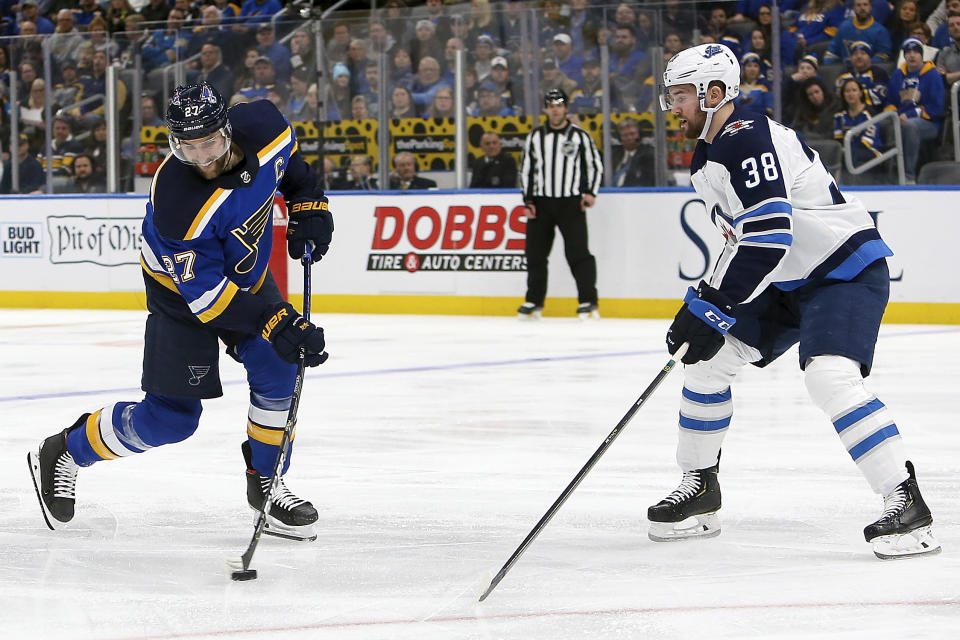 St. Louis Blues' Alex Pietrangelo (27) shoots the puck past Winnipeg Jets' Logan Shaw (38) during the second period of an NHL hockey game Thursday Feb. 6, 2020, in St. Louis. (AP Photo/Scott Kane)