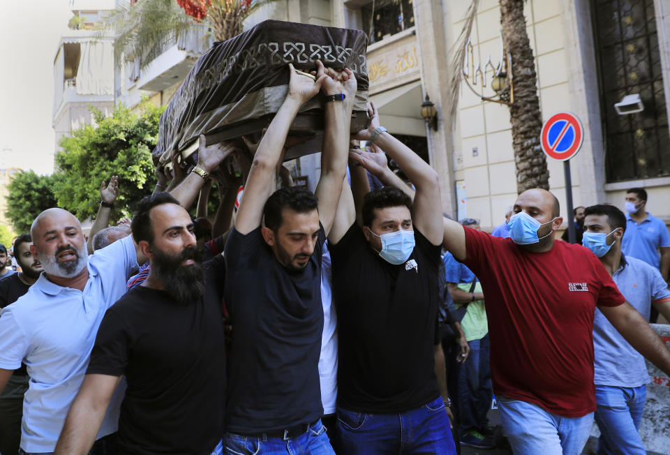 Mourners carry the coffin of Ibrahim Harb, 35, who was critically injured in the massive explosion at Beirut's port last year and who died on Monday nearly 14 months after the blast, in Beirut, Lebanon, Tuesday, Sept. 28, 2021. On Aug. 4, 2020, hundreds of tons of ammonium nitrate, a highly explosive material used in fertilizers, ignited after a massive fire at the port. The death brings to at least 215 the number of people who have been killed by the blast, according to official records. (AP Photo/Hussein Malla)