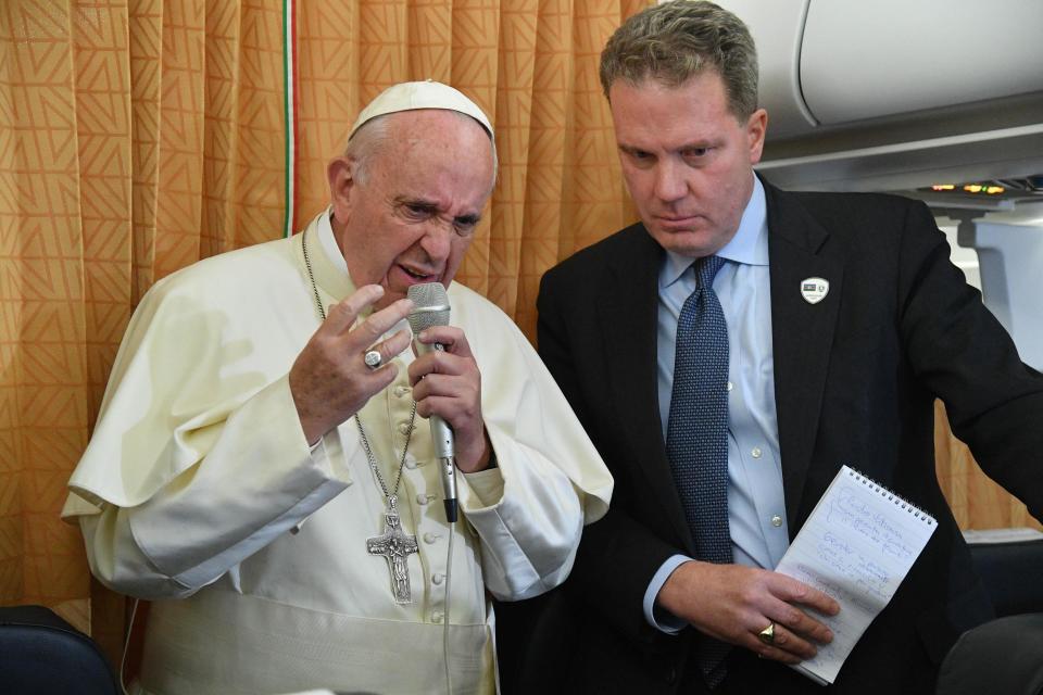 FILE - In this Sunday, Oct. 2, 2016 file photo, Pope Francis is flanked by Vatican Spokesman Greg Burke as he speaks with journalists on board the flight from Baku to Rome. The Vatican has called the sex abuse described in a grand jury report in Pennsylvania "criminal and morally reprehensible." In a statement released late Thursday, Aug. 16, 2018 Vatican spokesman Greg Burke said "those acts were betrayals of trust that robbed survivors of their dignity and faith." He said that victims should know that Pope Francis is on their side. (Luca Zennaro/Pool Photo via AP)