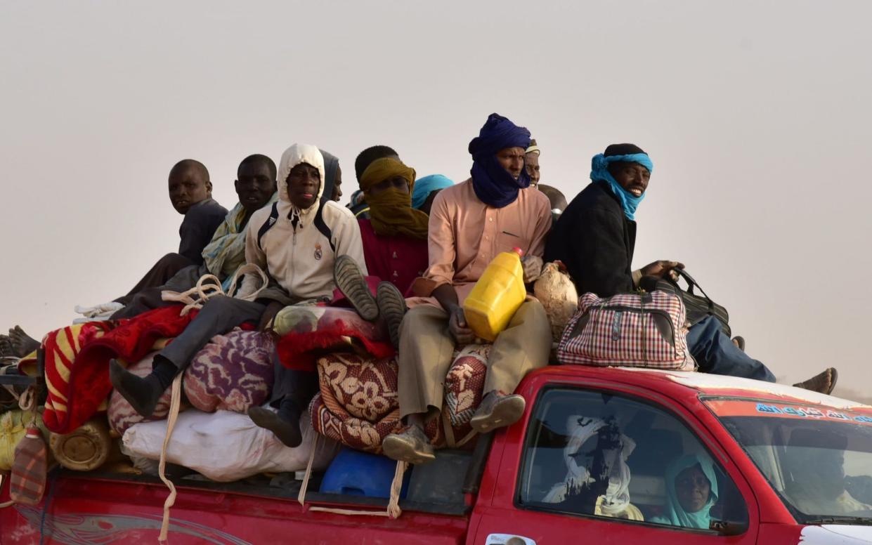 West African migrants on a pick-up truck near the Libya-Niger border, in the Sahara Desert - AFP