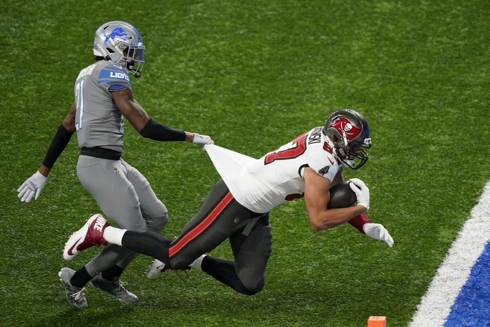 Tampa Bay Buccaneers tight end Rob Gronkowski (87) defended by Detroit Lions defensive back Tracy Walker (21) falls into the end zone for a touchdown during the first half of an NFL football game, Saturday, Dec. 26, 2020, in Detroit. (AP Photo/Carlos Osorio)