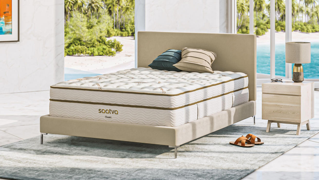  The Saatva Classic mattress sat on a luxury bed base in a room overlooking a blue pool on a sunny day. 