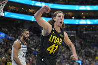 Utah Jazz forward Kelly Olynyk (41) gestures to a referee after being called for a foul on Minnesota Timberwolves center Rudy Gobert, rear, during the first half of an NBA basketball game Friday, Dec. 9, 2022, in Salt Lake City. (AP Photo/Rick Bowmer)