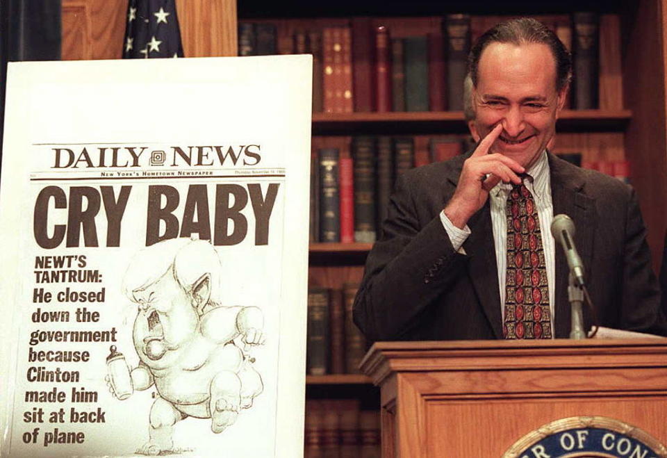 Rep. Charles Schumer jokes with reporters about Gingrich on a tabloid's front page of in 1995 on Capitol Hill in Washington, DC.<span class="copyright">Richard Ellis—AFP via Getty Images</span>