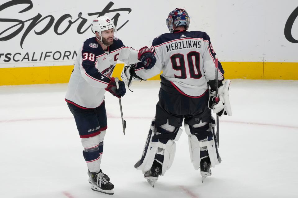 Columbus Blue Jackets center Boone Jenner (38) is congratulated by goaltender Elvis Merzlikins (90) after scoring a goal against the San Jose Sharks during the third period of an NHL hockey game in San Jose, Calif., Saturday, Feb. 17, 2024. (AP Photo/Jeff Chiu)