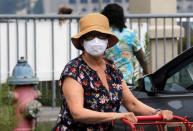 People wear protective face masks outside at a shopping plaza in Edgewater New Jersey