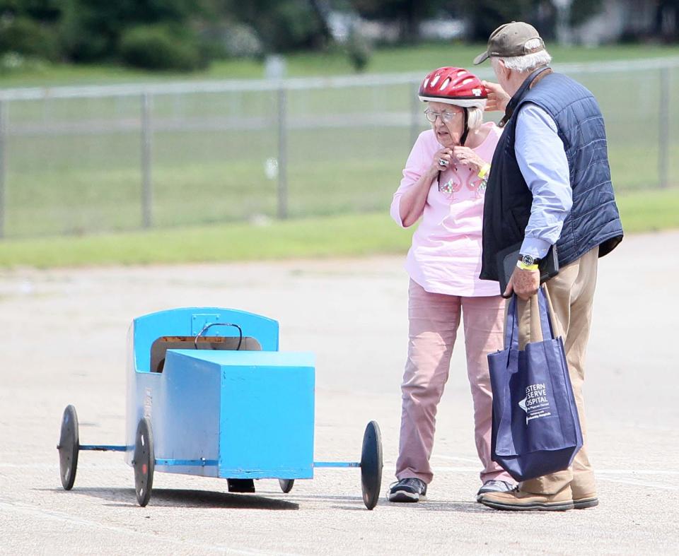 Kennon Callahan assists his wife Julie Callahan with removing her helmet after racing down the hill at Derby Downs during Senior Day on Thursday.
