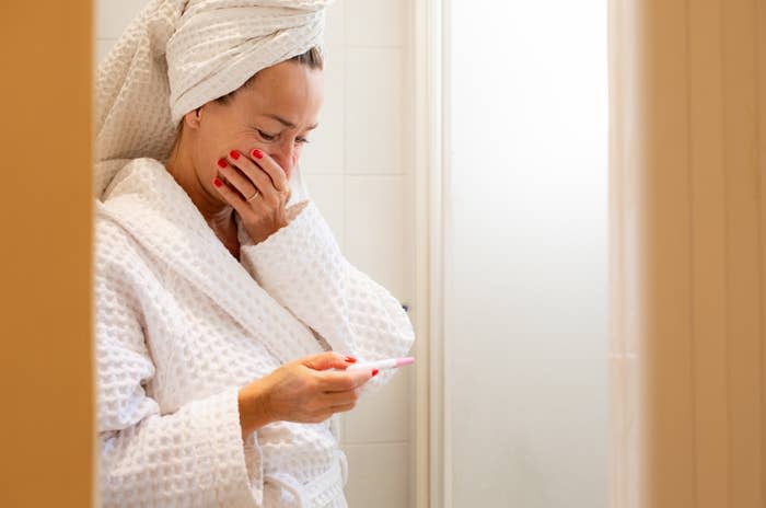 woman gasping looking at pregnancy test