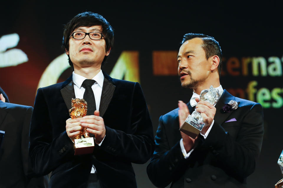 Director Diao Yinan, left, with the Golden Bear for Best Film and actor Fan Liao, right, with the Best Actor Silver Bear for the film Black Coal, Thin Ice, during the award ceremony at the International Film Festival Berlinale in Berlin, Saturday, Feb. 15, 2014. (AP Photo/Axel Schmidt)