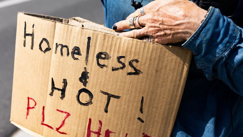 Stephen Bowen holds a sign that says “Homeless and hot! Plz help” on State Street in Salt Lake City on Friday. The potential deadly summer heat has mobilized community members with charitable organizations to help the homeless cool down.