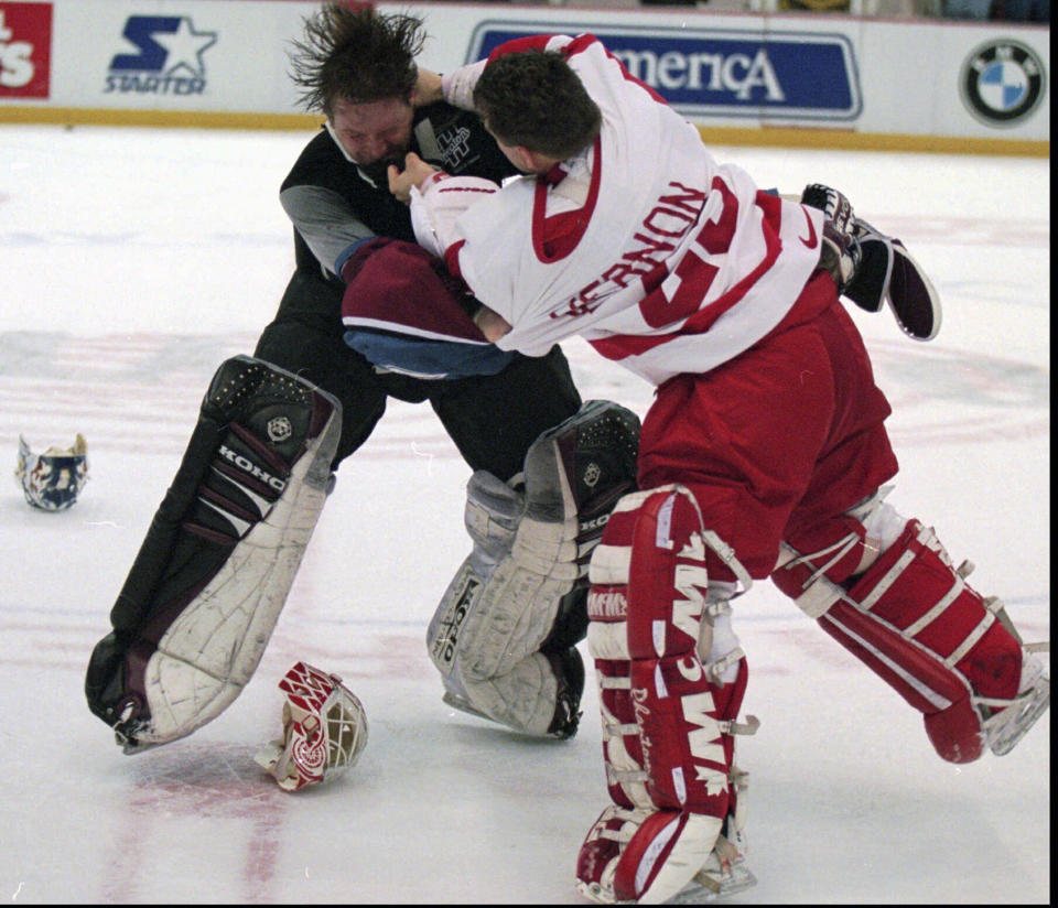 FILE - Colorado Avalanche goaltender Patrick Roy, left, takes a punch from Detroit Red Wings' goaltender Mike Vernon during a first-period brawl in Detroit, March 26, 1997. League rule changes have made it so punitive that goalie fighting has essentially disappeared from the highest level of hockey. (AP Photo/Tom Pidgeon, File)