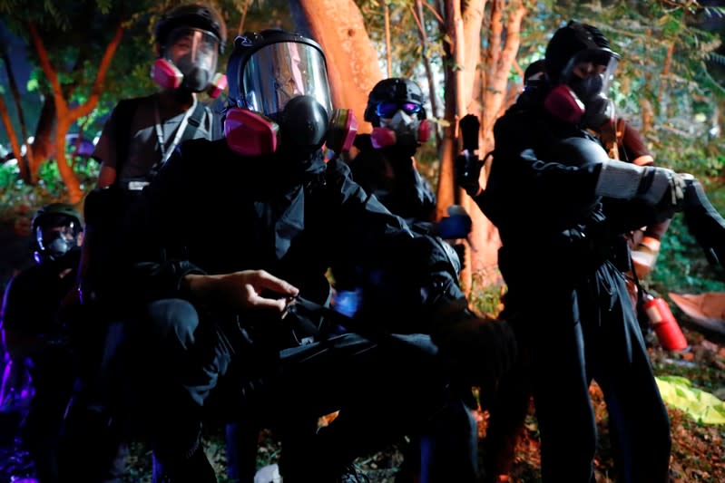 Anti-government protesters take cover during a standoff with riot police at the Chinese University of Hong Kong, Hong Kong