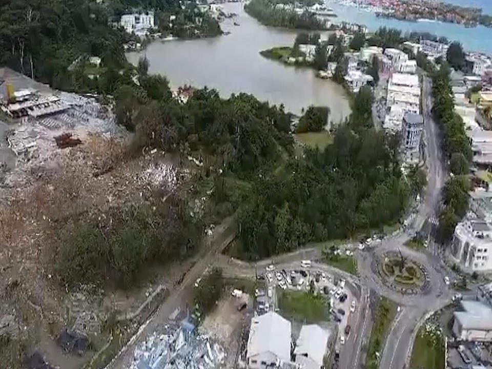 In this image made from video, Buildings damaged after a massive explosion at an industrial area on the main island in Mahe, Seychelles, Thursday, Dec. 7, 2023. The president of Seychelles declared a state of emergency on Thursday after a huge blast at an explosives depot and flooding in other parts of the country's main island. (AP Photo/Emilie Chetty)