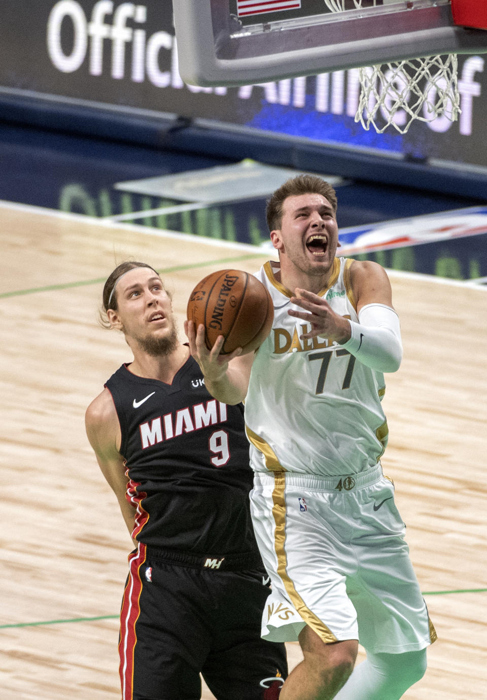Dallas Mavericks guard Luka Doncic (77) shoots as Miami Heat forward Kelly Olynyk (9) tries to avoid fouling him during the first half of an NBA basketball game Friday, Jan. 1, 2021, in Dallas. (AP Photo/Jeffrey McWhorter)