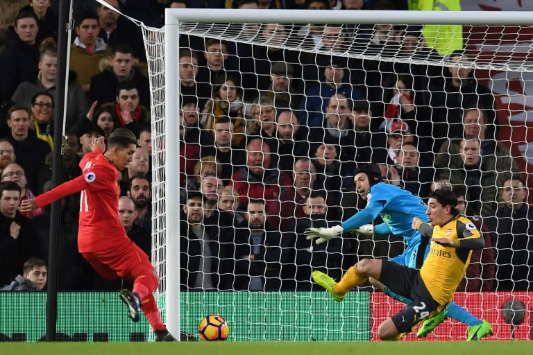 Liverpool's midfielder Roberto Firmino (L) prepares to shoot past Arsenal's goalkeeper Petr Cech to score the opening goal of the English Premier League football match March 4, 2017