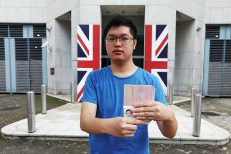 Wilson Li, who was born five months before the Hong Kong's handover to Chinese rule in 1997, poses with his British national (Overseas) passport issued in 1997, outside British Consulate-General, in Hong Kong, China June 15, 2017. REUTERS/Tyrone Siu