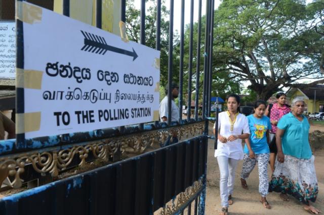 Sri Lankan voters leave a polling station after casting their ballots in the town of Tangalla, some 195 kms from the capital Colombo, on August 17, 2015