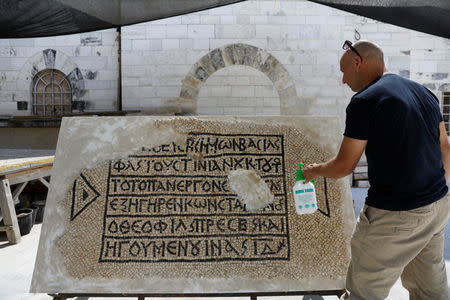 A conservationist works on a 1500-year-old mosaic floor bearing a Greek writing, discovered near Damascus Gate in Jerusalem's Old City, as it is displayed at the Rockefeller Museum in Jerusalem August 23, 2017. REUTERS/Ronen Zvulun