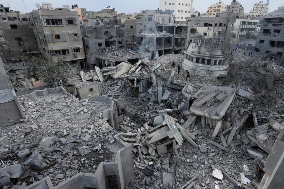 Palestinians inspect the rubble of the Yassin Mosque destroyed after it was hit by an Israeli airstrike at Shati refugee camp in Gaza City, early Monday, Oct. 9, 2023.