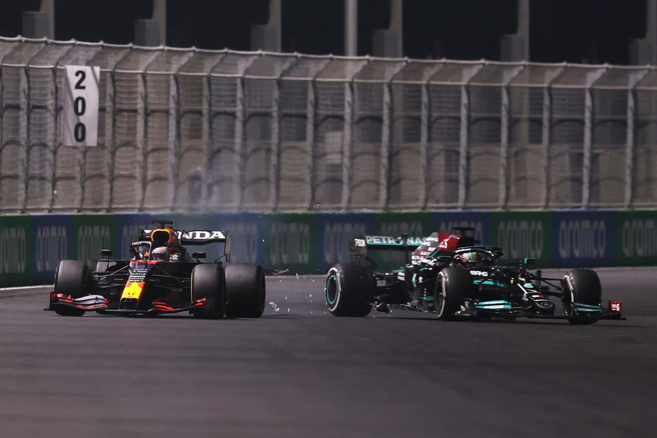 JEDDAH, SAUDI ARABIA - DECEMBER 05: Max Verstappen of the Netherlands driving the (33) Red Bull Racing RB16B Honda and Lewis Hamilton of Great Britain driving the (44) Mercedes AMG Petronas F1 Team Mercedes W12 collide during the F1 Grand Prix of Saudi Arabia at Jeddah Corniche Circuit on December 05, 2021 in Jeddah, Saudi Arabia. (Photo by Lars Baron/Getty Images)