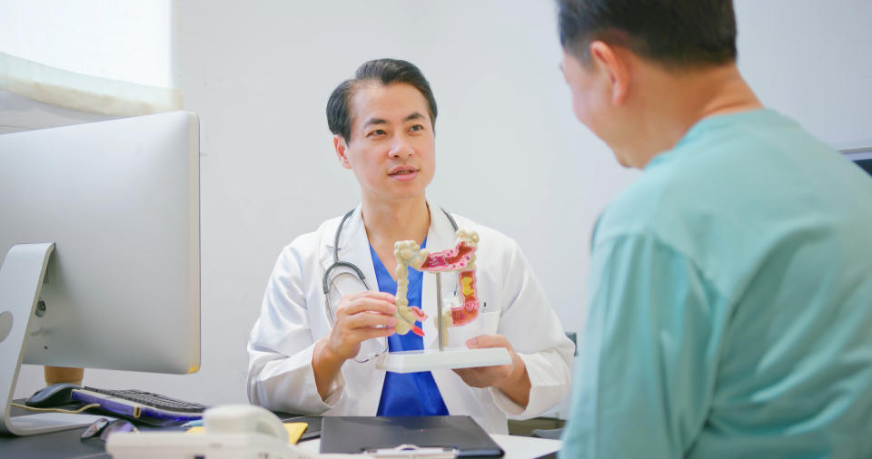 Doctor showing a patient a model of the colon