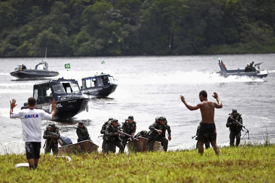 Brazilian Army soldiers land at a community along the Oyapock river that divides Brazil from French Guiana during the operation named "Agata" near the town of Oiapoque, May 15, 2014. Operation Agata is a Brazilian armed forces operation in coordination with other federal agencies to combat cross-border crimes such as drug trafficking, smuggling of arms and goods, environmental crimes, illegal immigration, and illegal mining. Picture taken May 15, 2014. REUTERS/Ueslei Marcelino (BRAZIL - Tags: POLITICS MILITARY)