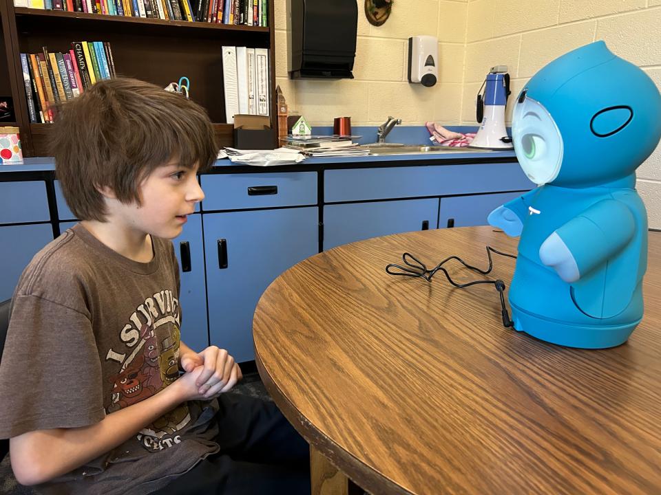 Wolverine third grader William Trugillo practices using the Moxie robot the district is introducing.