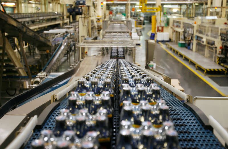 FILE PHOTO: Bottles soft drinks made by drinks company Britvic sit on a conveyor belt at Britvic's bottling plant in London